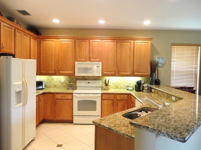 kitchen the stunning kitchen has granite counters with full tumblestone backsplash as well as 42: wood cabinetry with crown molding and under cabinet lighting.