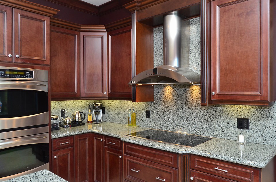 kitchen in addition there is a stainless steel ge monogram vented hood and 5 burner flat top stove