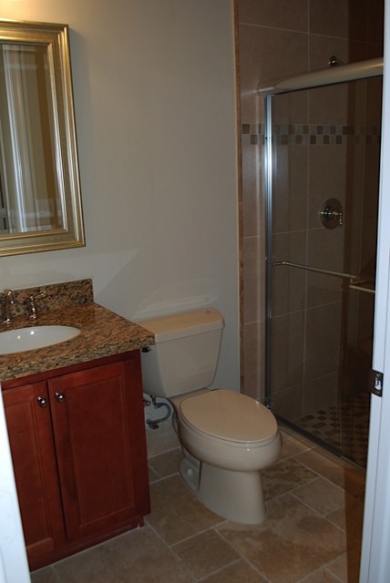 the guest bathroom features granite counters & upgraded tile.